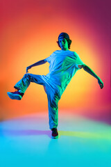 Fototapeta na wymiar Conceptual portrait of young man, hip-hop dancer in stylish clothes in action isolated on colorful background at dance hall in neon light.