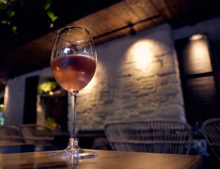 Glass of chilled rose wine on a restaurant table.