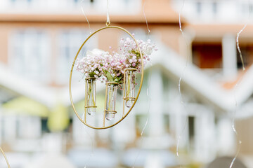 Hanging small glass containers with white hydrangeas. Small decorations for an arch. Wedding arch for free weddings. Boho decorations for outdoor wedding ceremonies 