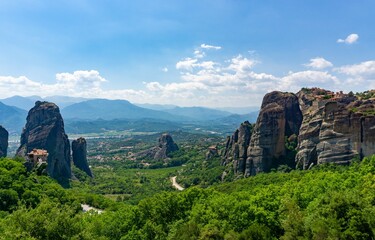 Fototapeta na wymiar Panoramic view of Meteora with blue sky full of clouds and green forest