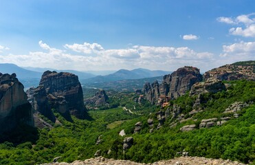 Fototapeta na wymiar Panoramic view of Meteora with blue sky full of clouds and green forest