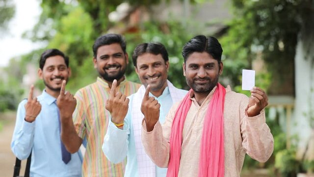 Young Indian farmers showing finger after voting with officers.