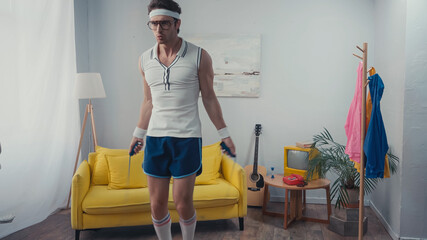 sportsman exercising with jump rope in living room, retro sport concept