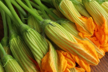 Fresh zucchini flowers on dark rustic background