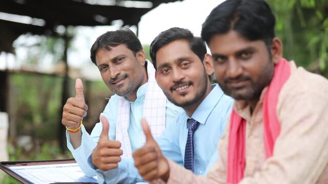 Young indian farmers showing thumps up with banker or agronomist.