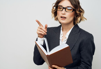woman in business suit with a book in his hands light background