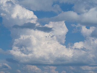 Huge beautiful clouds in the blue sky. Intricate shaped multicolored clouds. Natural Heavenly postcard