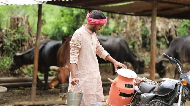 Rural scene : Indian milkman distribute milk on bike