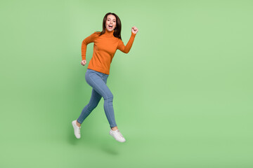 Fototapeta na wymiar Full length body size view of attractive confident cheerful girl jumping running motion action isolated over bright green color background
