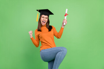 Portrait of attractive trendy cheerful girl rejoicing master degree having fun great day isolated over green color background