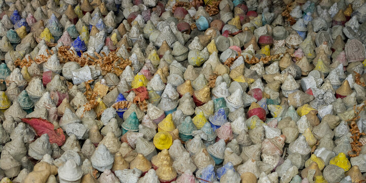 Closeup view of traditional tsatsa votive stupa offerings at Membartsho or Mebar Tsho holy lake, Bumthang valley, Bhutan
