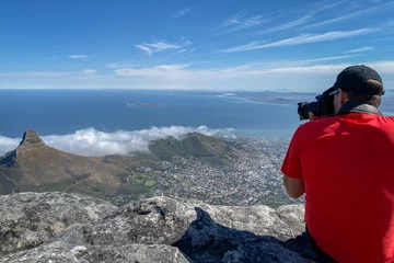 Papier Peint photo autocollant Montagne de la Table Man taking pictures of Cape Town cityscape.
