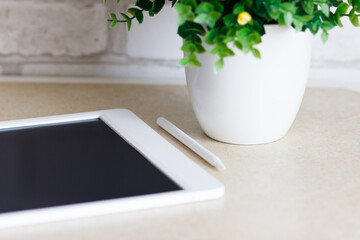 White tablet on the table, blurred background