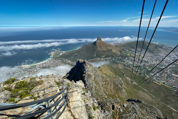 Panoramic view of Cape Town, Lions Head and Camps Bay with cable of cable car in foreground.
