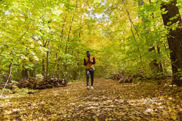 Obraz premium African american student walking in the park in autumn season