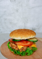 Pulled Chicken, Pork with lettuce, cucumber and tomato on a wooden board light background