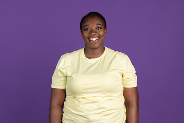Half-length portrait of African pretty woman isolated on purple, lilac color studio background. Concept of human emotions, facial expression, natural beauty, bodypositive