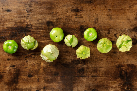 Tomatillos, green tomatoes, shot from above with copy space. Mexican cuisine ingredient on a dark rustic wooden background