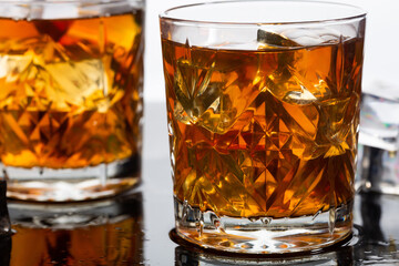 Whiskey in old fashioned glasses with ice, close up