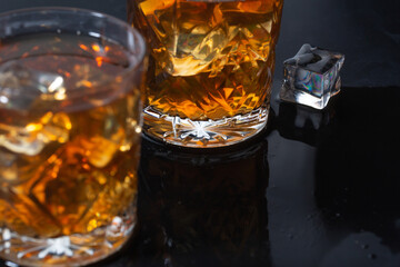whiskey with ice in glasses close-up, strong alcohol