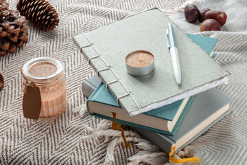 Hygge. Journals and scented candles on a warm blanket, lazy winter morning. Comfy still life