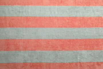 Striped beach towel as background, top view