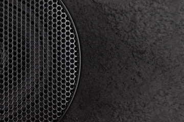 Stylish car audio acoustic round speaker with waffle grill protector cover on dark black background...