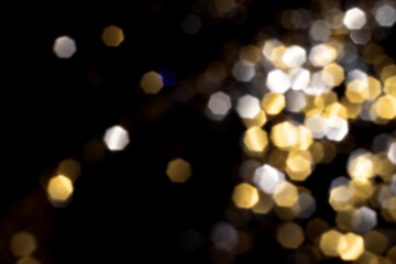 Golden and silver blurred bokeh lights on black background. Glitter sparkle stars for celebrate. Overlay for your design