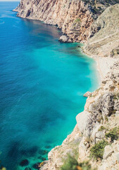 View from the cliff to the azure coast of the ocean. Rocks by the sea. Scenic view of the seaside