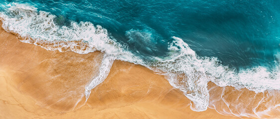 Sandy beach, panorama. Panoramic view of the sandy beach. The sea wave rolls on the shore. Sea coast view from the air. Aerial photography of the sea wave. The ocean and beach. Copy space