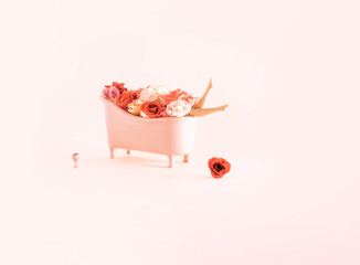 Spa treatment, bathing, relaxation, minimal creative concept. Bathtub, colorful roses and doll legs pastel pink composition. 