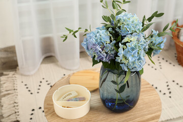 Beautiful blue hortensia flowers in vase on table indoors. Space for text