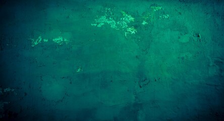 Old green wall in spots, cracks, stains. Painted concrete wall in abstract grunge style loft. Vintage wall background texture for backgrounds, portraits, posters.
