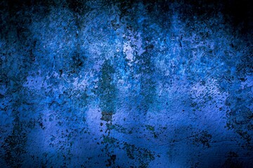 Old blue wall in spots, cracks, stains. Painted concrete wall in abstract grunge style loft. Vintage wall background texture for backgrounds, portraits, posters.