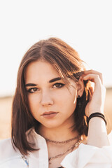 Fototapeta premium Teenage girl walks alone in nature in the summer. Schoolgirl with black hair relaxing