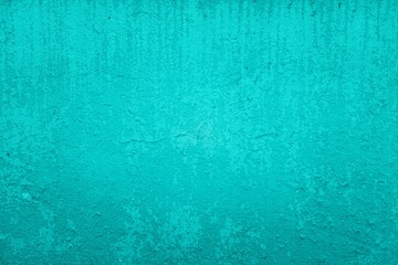 Old green wall in spots, cracks, stains. Painted concrete wall in abstract grunge style loft. Vintage wall background texture for backgrounds, portraits, posters.