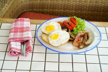 traditional breakfast on a plate on a table with a plaid tablecloth. 