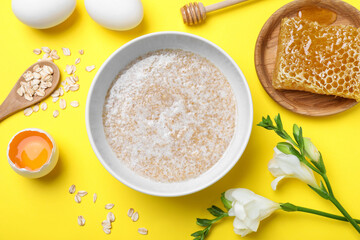 Homemade hair mask and ingredients on yellow background, flat lay
