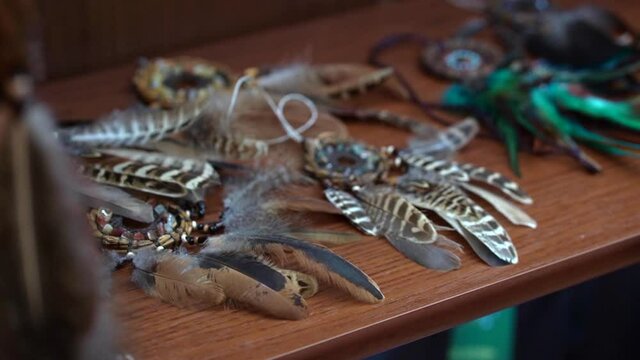 Blurred Dreamcatchers made of feathers leather beads and ropes on the shelf in the store