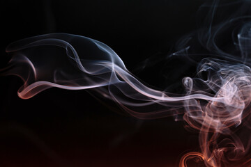 Abstract colored smoke moves on dark background. Wallpaper. Personal vaporizers fragrant steam....