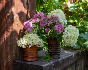 Still life with a bouquet of white and lilac flowers in a ceramic vase. Blooming hydrangea. Vintage.