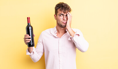 young handsome man feeling bored, frustrated and sleepy after a tiresome. wine bottle concept