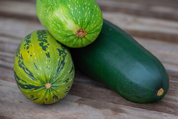 there are three zucchini on a wooden board