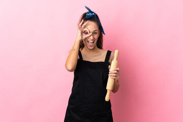 Young woman holding a rolling pin showing ok sign with fingers