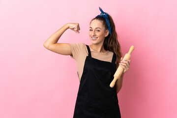 Young woman holding a rolling pin doing strong gesture