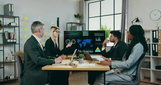 Attractive confident experienced mixed race people discussing ecological problems during joint meeting in boardroom