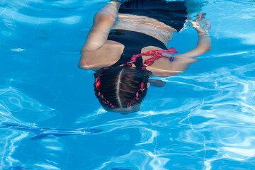Girl 9 years old swims in the pool