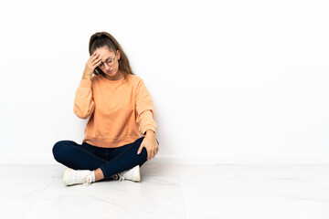 Young woman sitting on the floor with headache