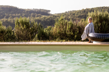 petite fille avec sa bouée au bord dfe la piscine