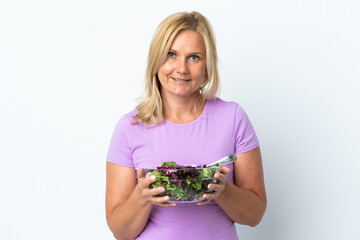 Middle age Lithuanian woman isolated on white background holding a bowl of salad with happy expression